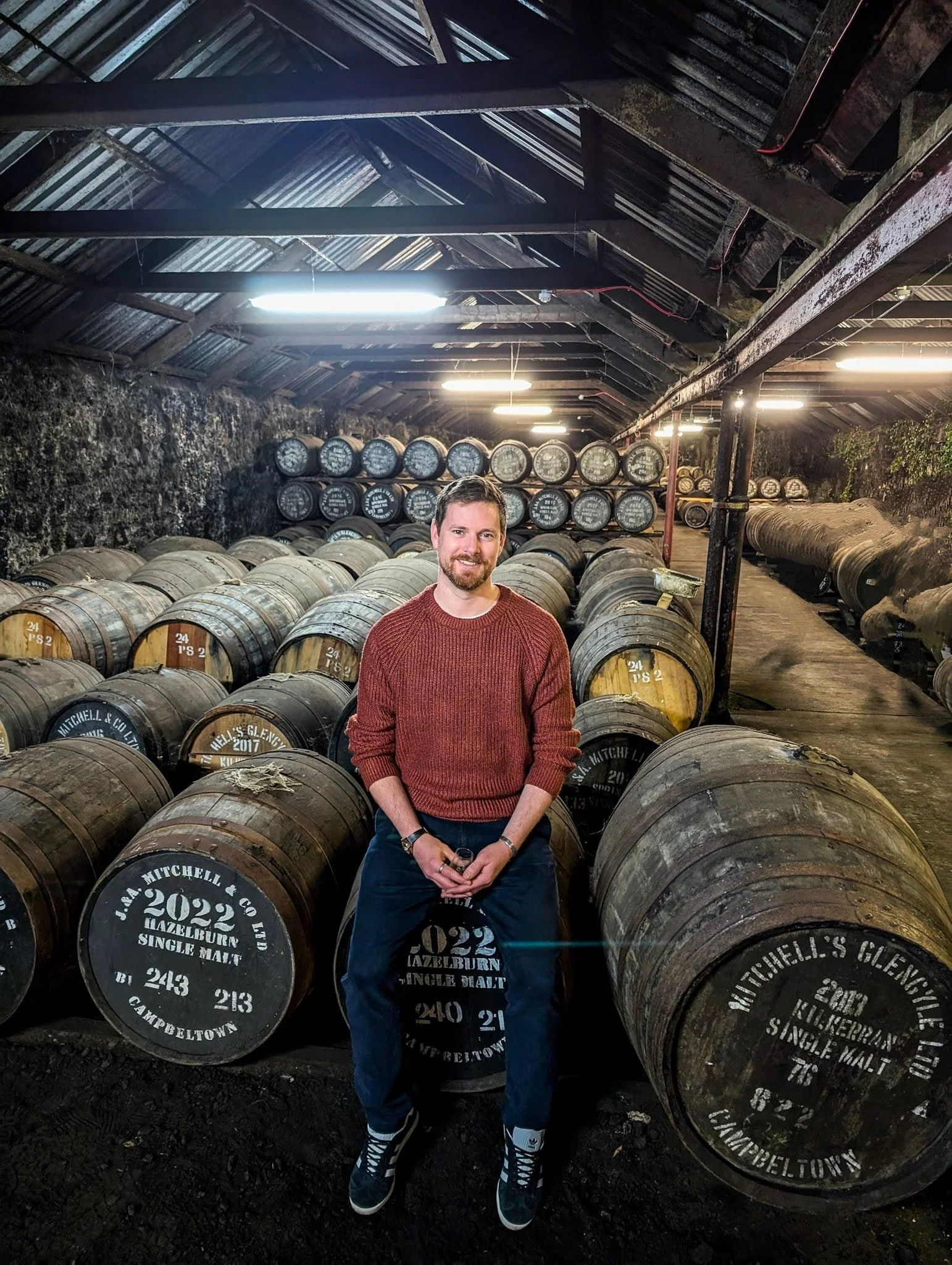 James Bunting sat on a barrel in a warehouse