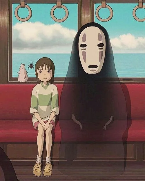 Le voyage de Chihiro Une fille assise dans un bus avec une créature à côté d'elle, une chatte, une araignée sur la fenêtre avec un paysage marin en arrière-plan.