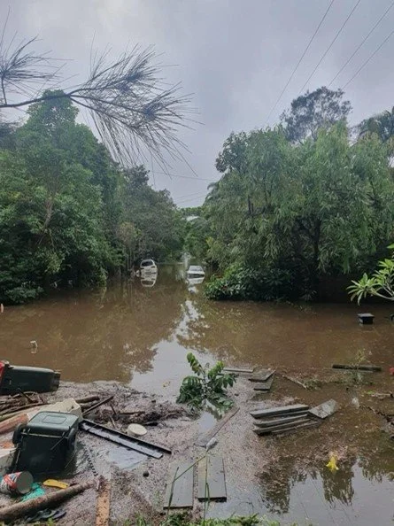 Photo of a flooded back yard in Australia with rubbish and debris everywhere