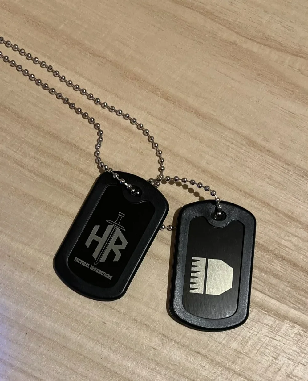 Image of two dog tags on a silver chain, engraved with paintball player's details