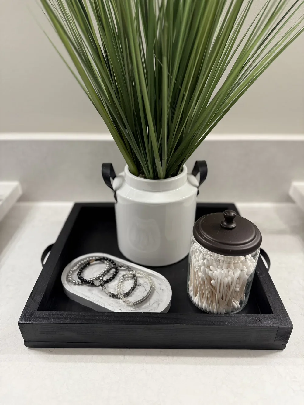 Black wooden tray with decor items in it