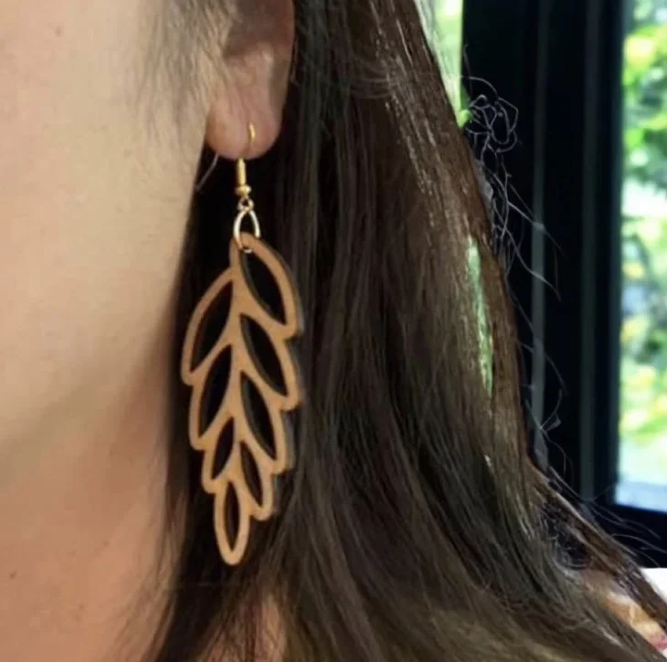 Woman wearing leaf shaped earrings made of wood
