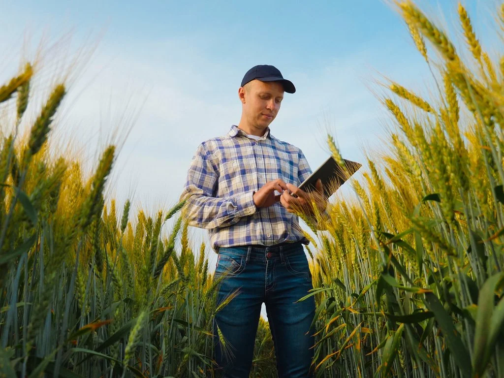 Farmer reviewing the One Big Beautiful Bill Act in Indiana field.