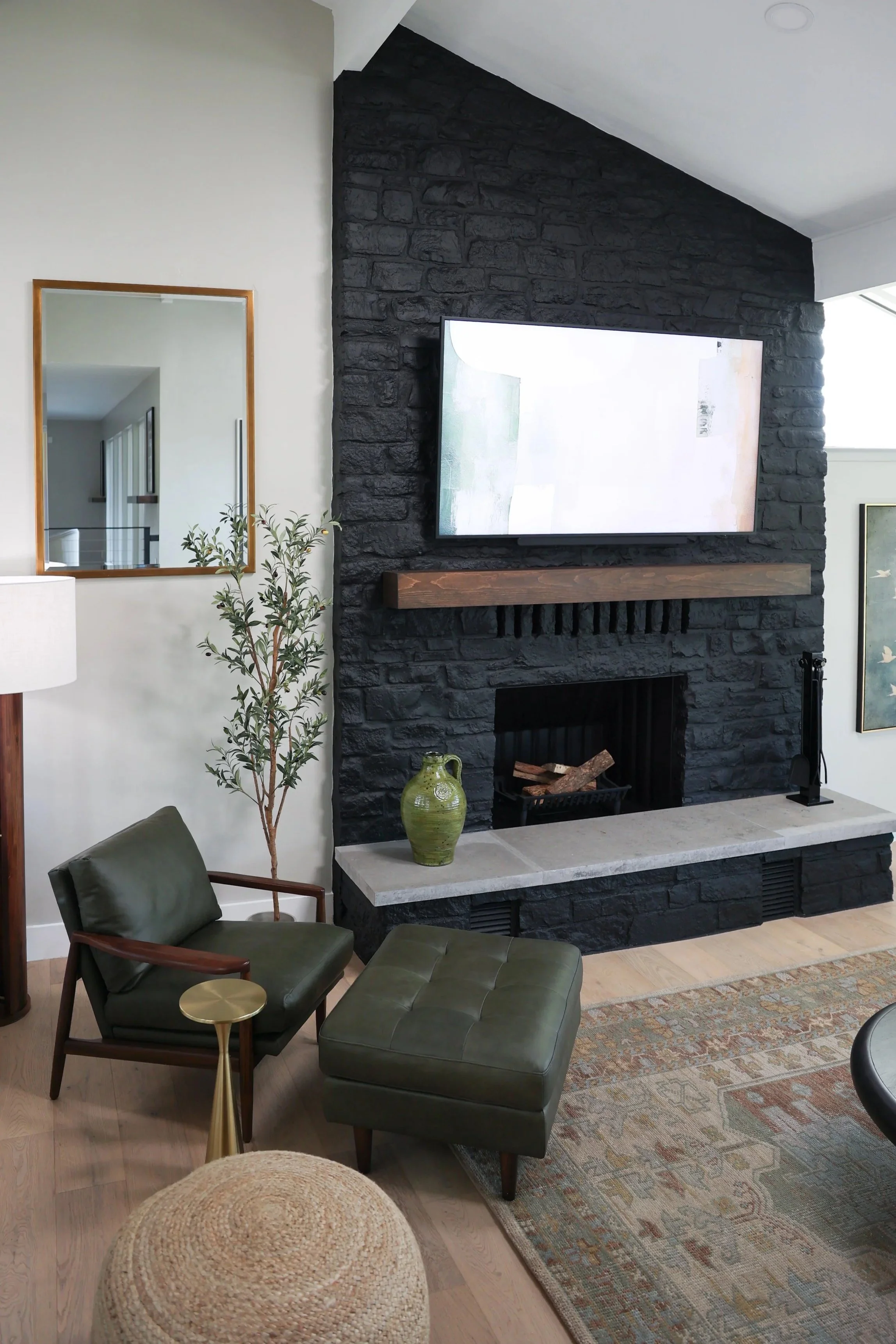 Living room with green leather chair and black fireplace