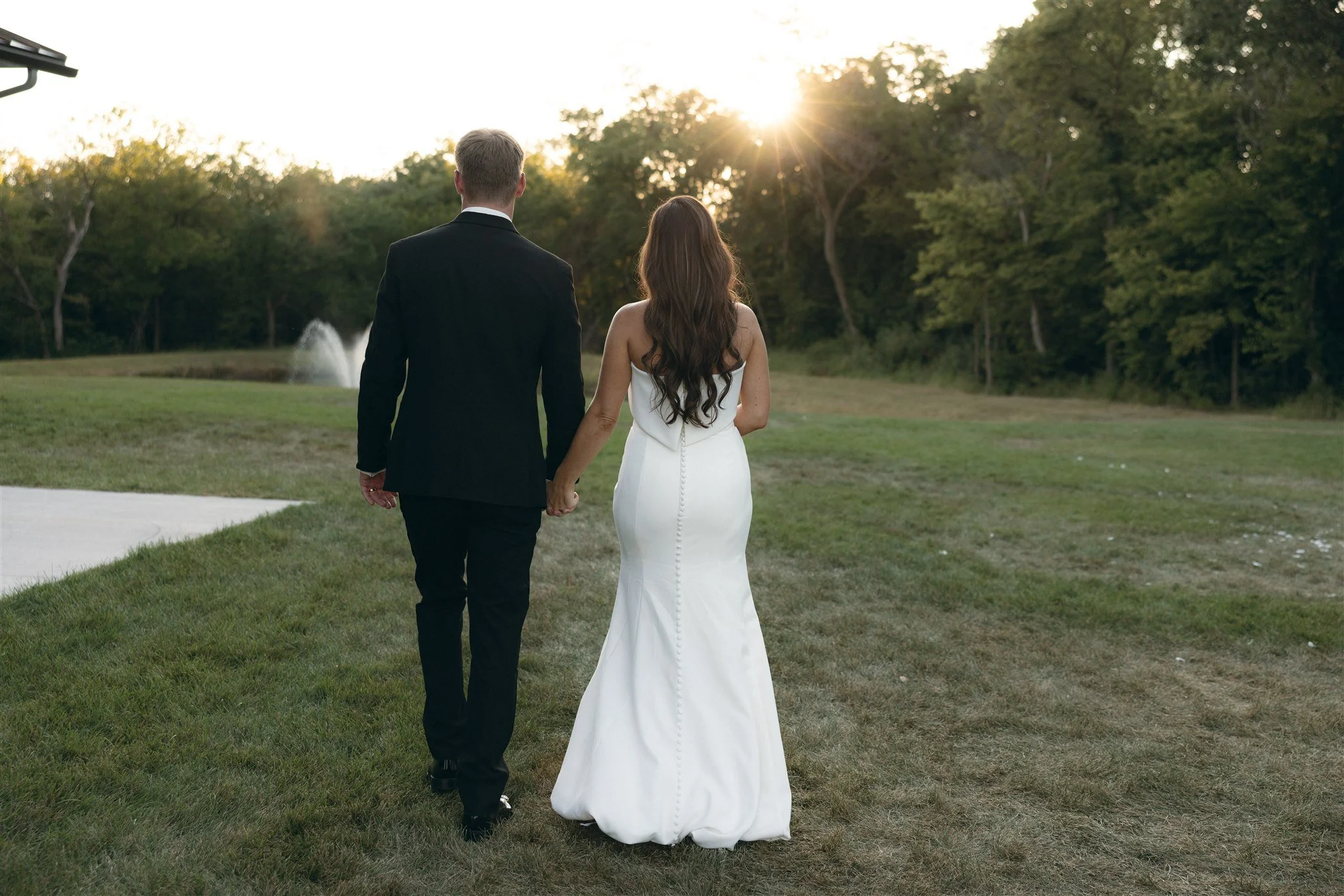 Bride and groom gazing lovingly into each other’s eyes in a golden autumn field surrounded by trees with vibrant fall foliage. A romantic and timeless moment at a scenic wedding venue in Des Moines, perfect for a cozy fall wedding.