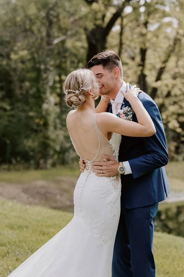 Bride and groom sharing a romantic embrace by the pond during their first look, just inside Des Moines near Altoona and Pleasant Hill. A peaceful, heartfelt moment captured at a charming outside wedding venue surrounded by natural beauty.