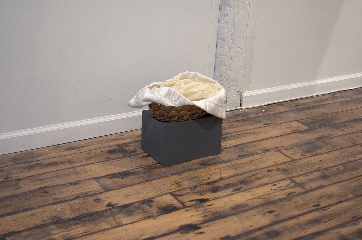 Offering, 2005. Antique basket and blanket (wicker, wool), cow intestines, beeswax, audio playback device, soundscape (3min loop). Approx. 14x10x12in (installation view)