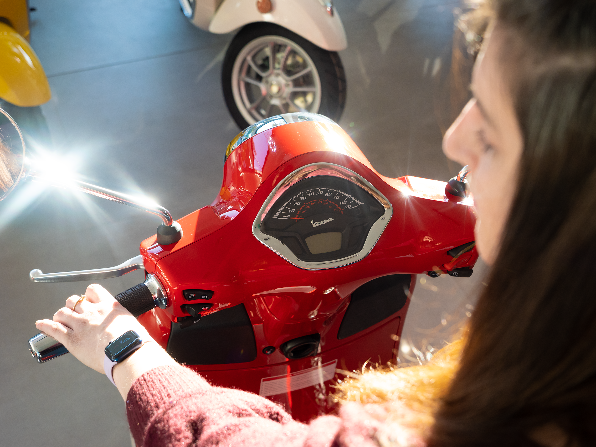 woman-seated-on-red-vespa-in-showroom.png
