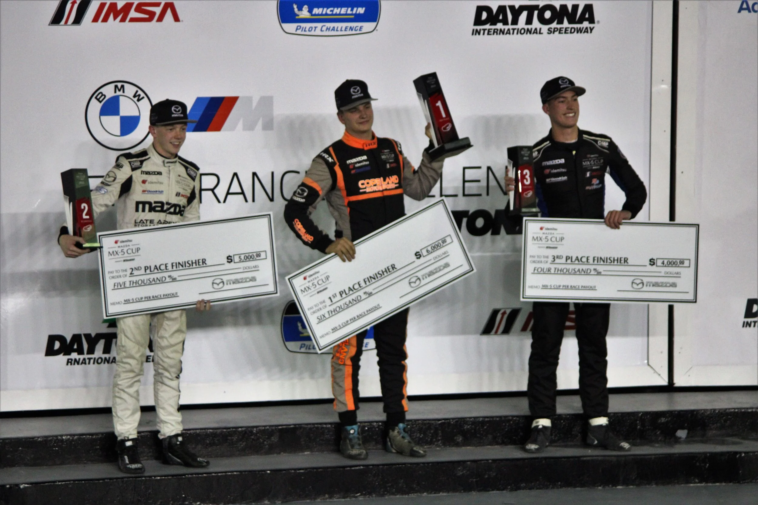  Tyler Gonzales (M), Connor Zilisch (L), and Sam Paley (R) stand on the podium following a thrilling Mazda MX-5 Cup finish. 