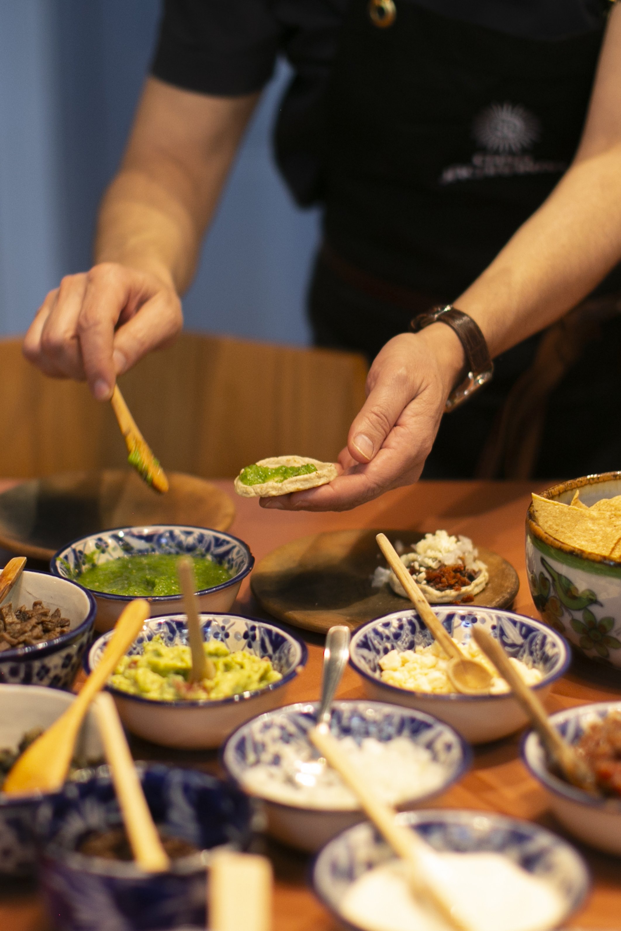 Hands plate up finished dishes after Casa Jacaranda's cooking class