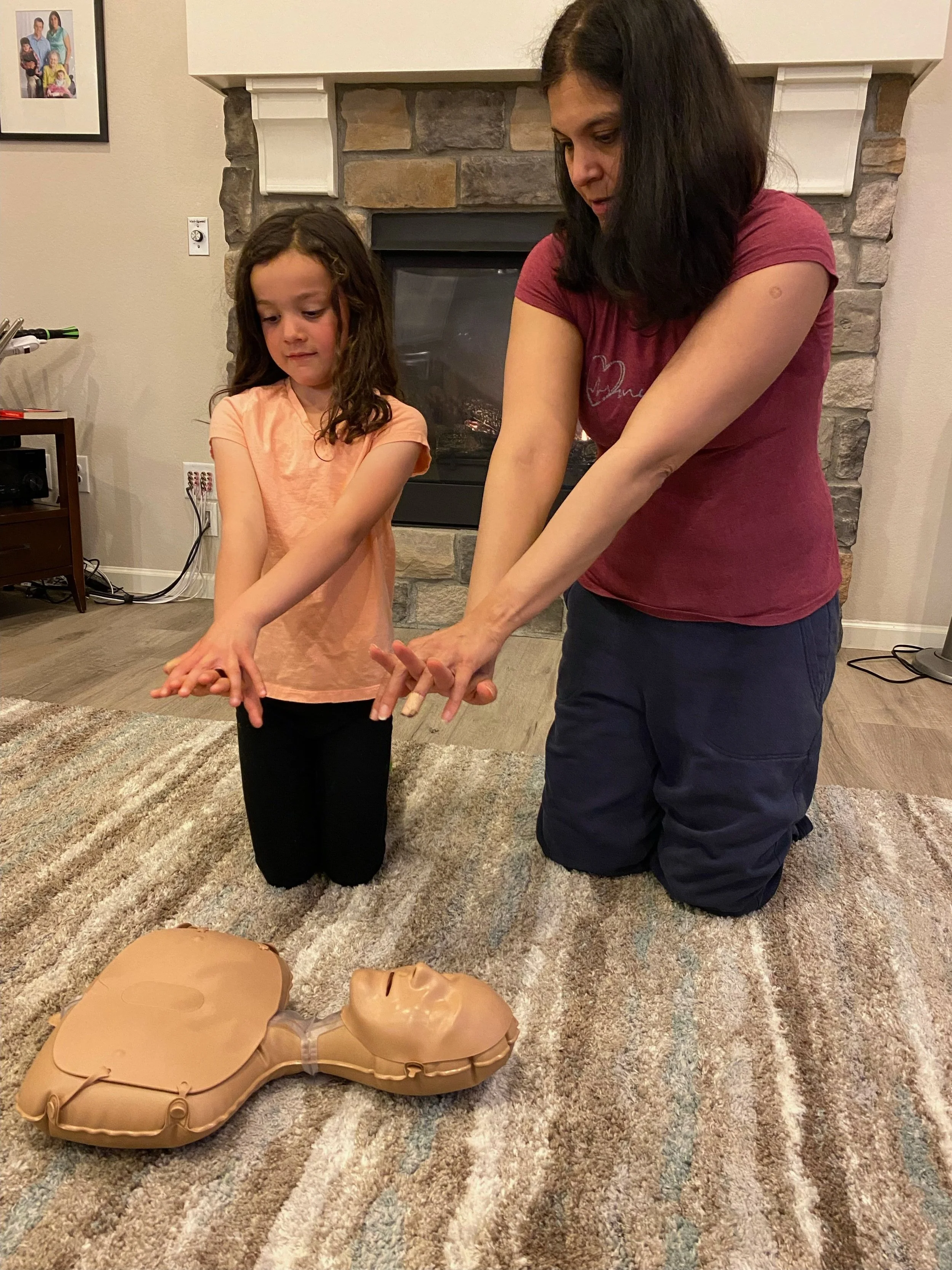 Mom showing daughter proper CPR form