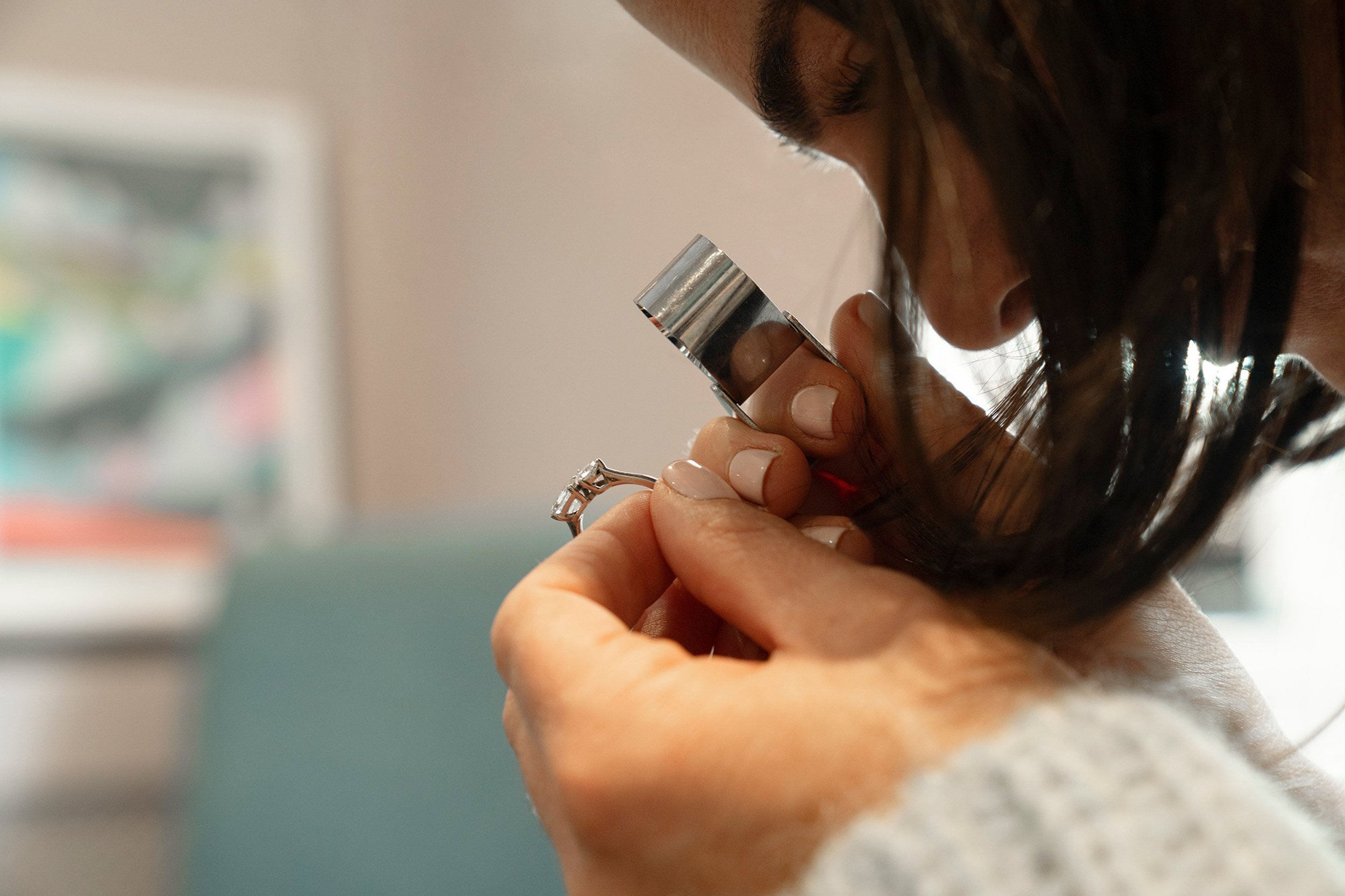 white-female-jeweller-checking-diamond-ring.jpg