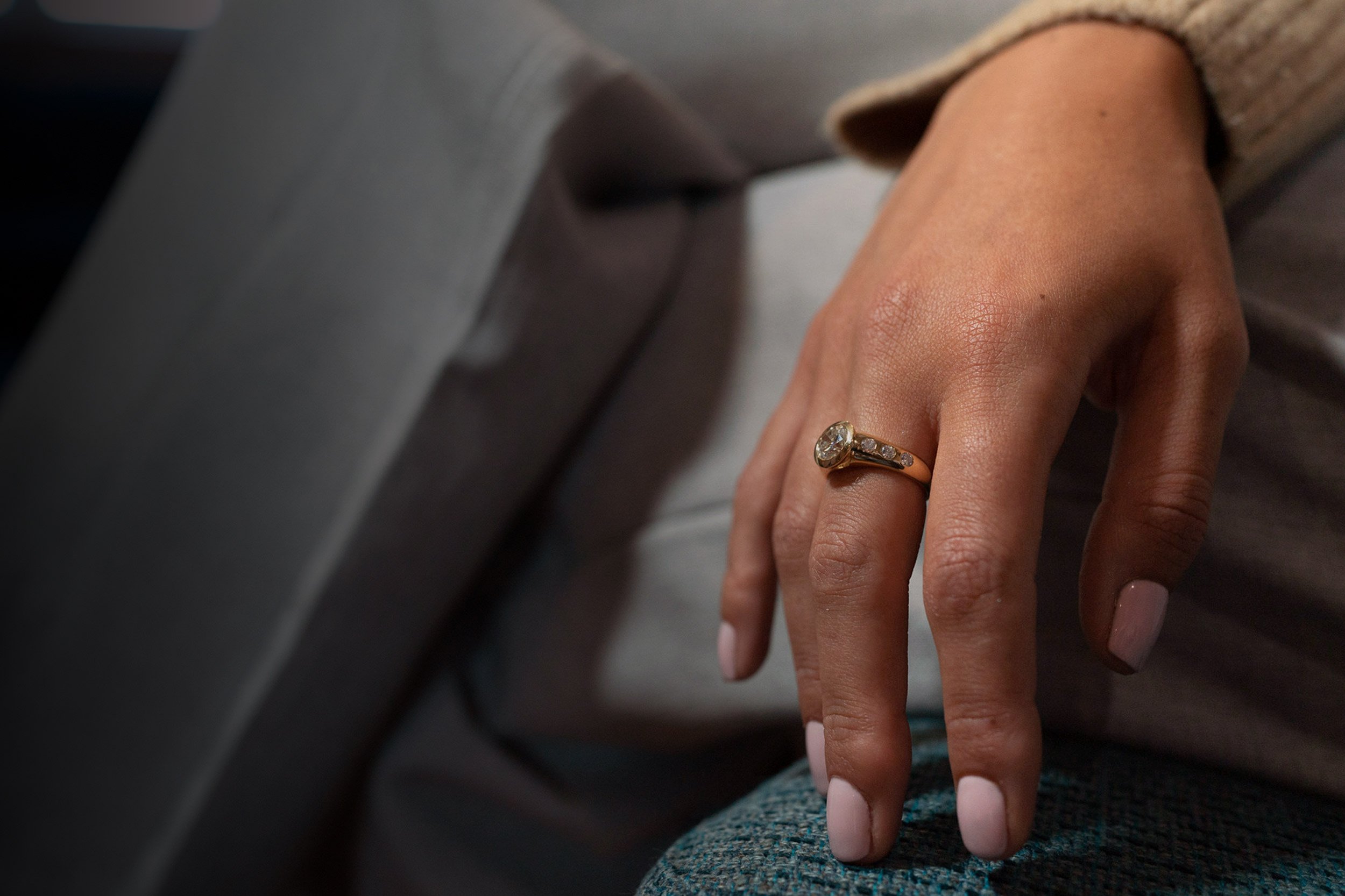 white-female-hand-resting-on-leg-wearing-gold-diamond-ring.jpg