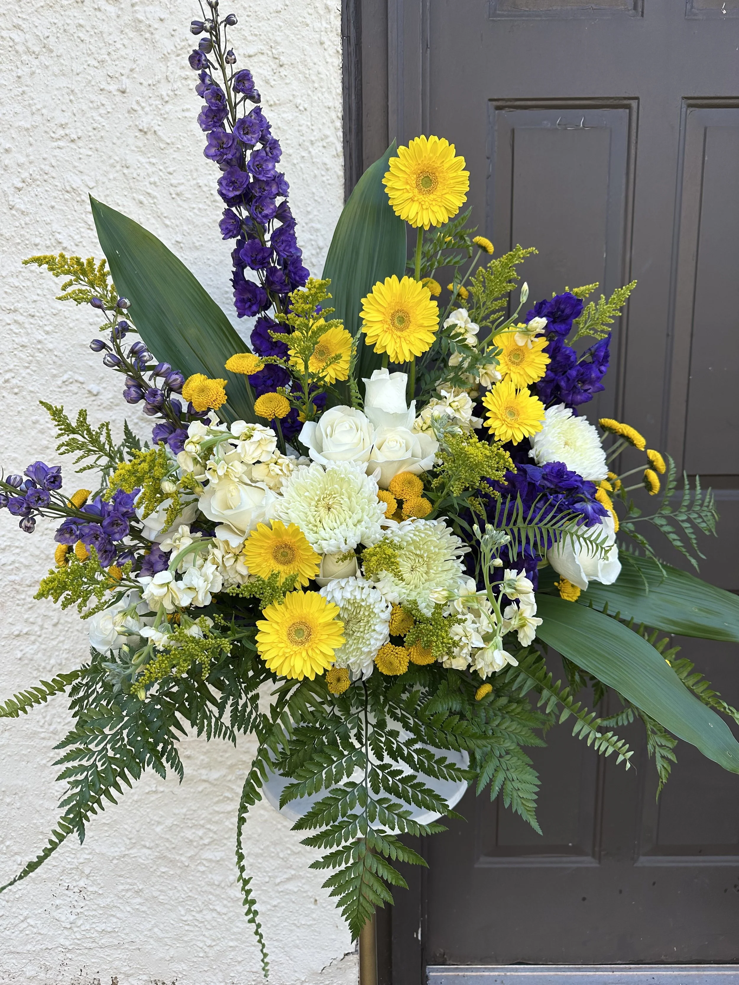Funeral urn with yellows and purples and whites. Event florist, Longmeadow MA, Spring flowers. Dee’s Floral Design in Longmeadow MA