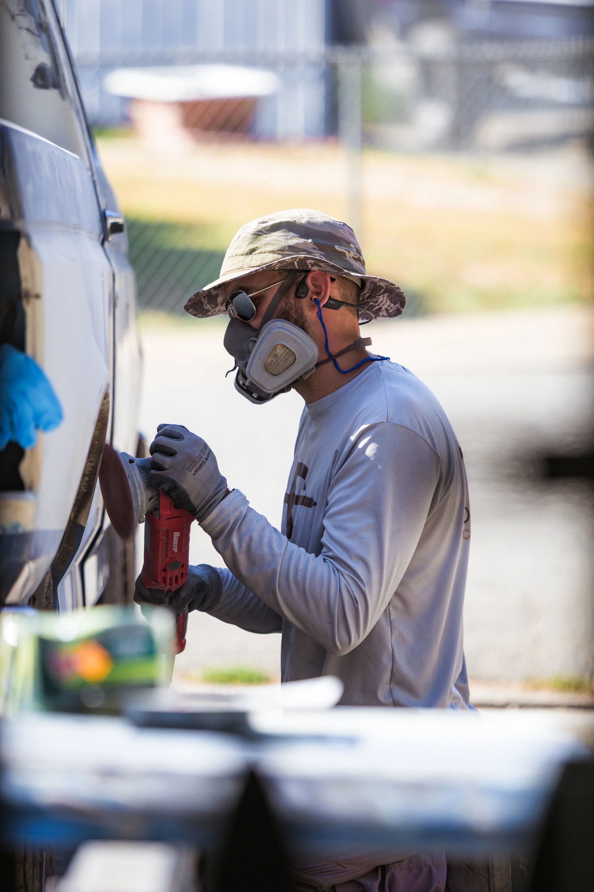 A general contractor working with a power tool to clean a metal surface before working on the project.