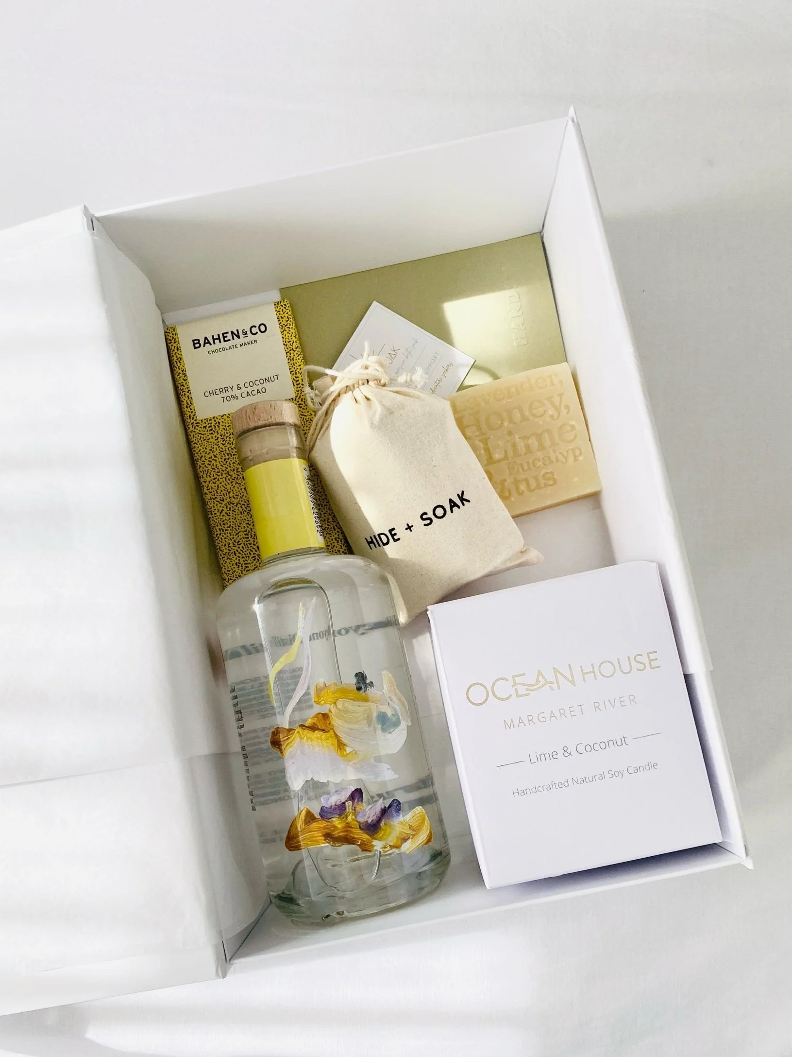 A Gin Lovers Gift Hamper featuring a bottle of gin bbeyond distilling in a beautiful white magnetic gift box, featuring Hide & Soak bath salts, Bahen & Co chocolate and a soy candle by Ocean House Candles. A beautiful gift designed by Handsy Hampers.