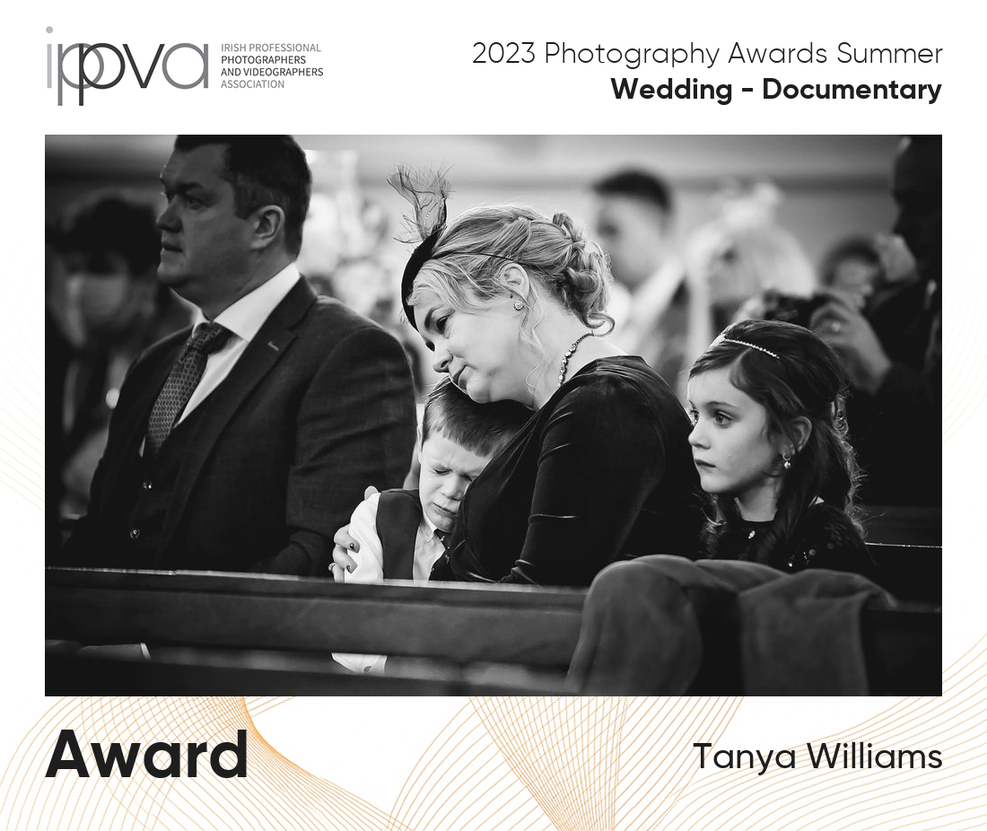 Award winning wedding photo of a mum embracing her upset son in the church pew during mass.