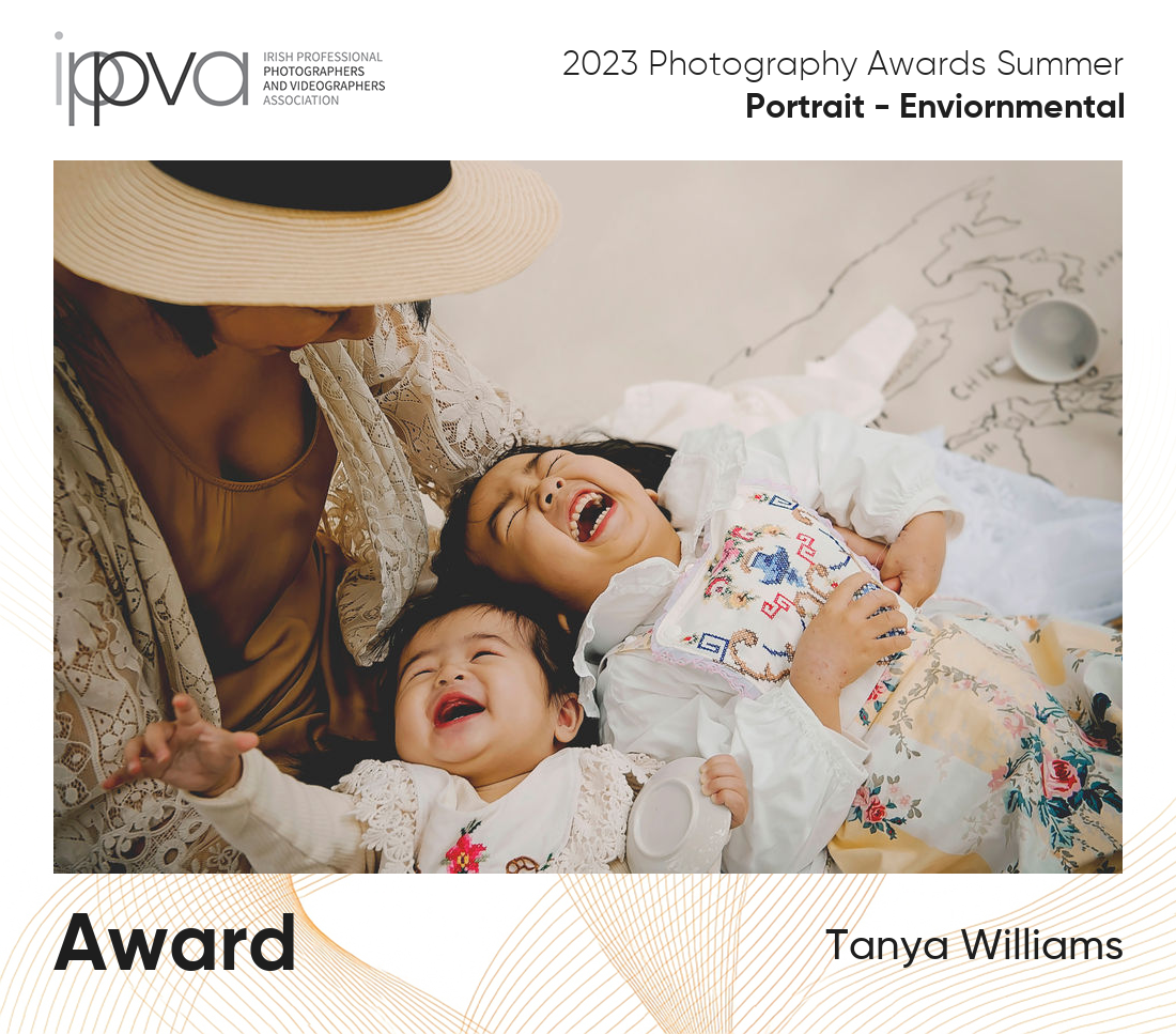 Award winning portrait photography photo  taken in natural light of a mum playing with her two daughters.