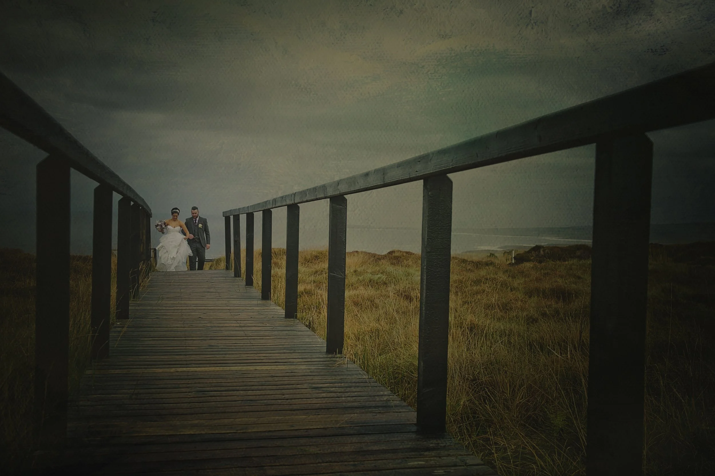 bride and groom walk along the walkway at the Céide fields in Mayo