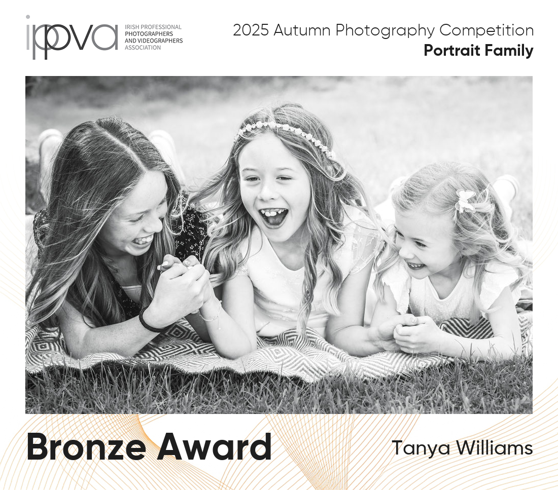 Award winning Communion photography of three sisters playing in the grass.