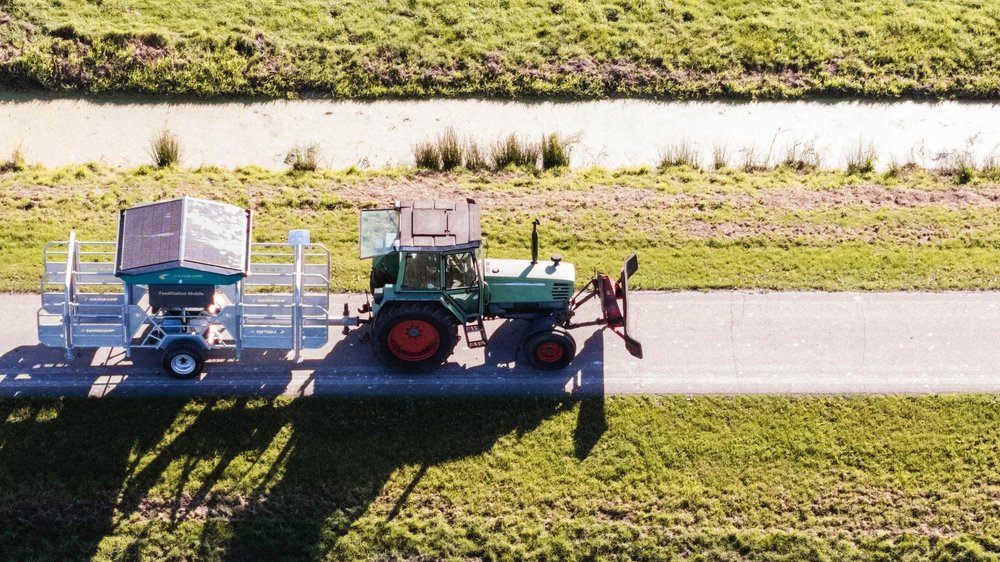Aerial view of a tractor towing the Hanskamp FeedStation Mobile between paddocks
