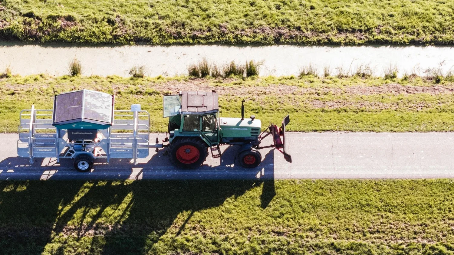 Aerial view of a tractor towing the Hanskamp FeedStation Mobile between paddocks
