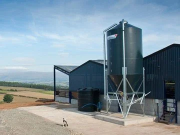 Collinson grain silo standing outside a farm shed