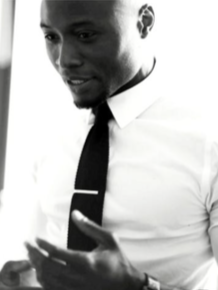 A man in a white shirt and black tie looking at his phone.