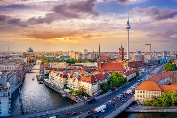 Übersicht über Berlin mit der Berliner Fernsehturm im Vordergrund, Spree, historische Gebäude und moderne Stadtarchitektur bei Sonnenuntergang.