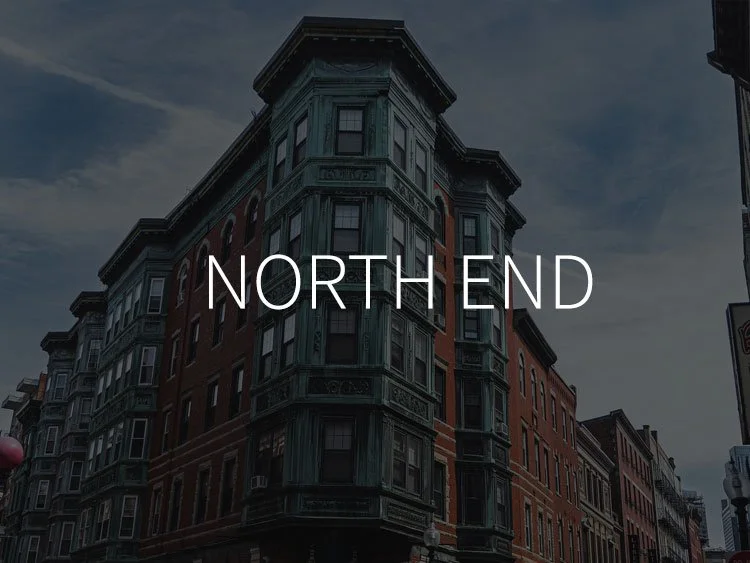 Image of a historic brick building with green ornamental trim on a city street with the text 'NORTH END' overlayed.