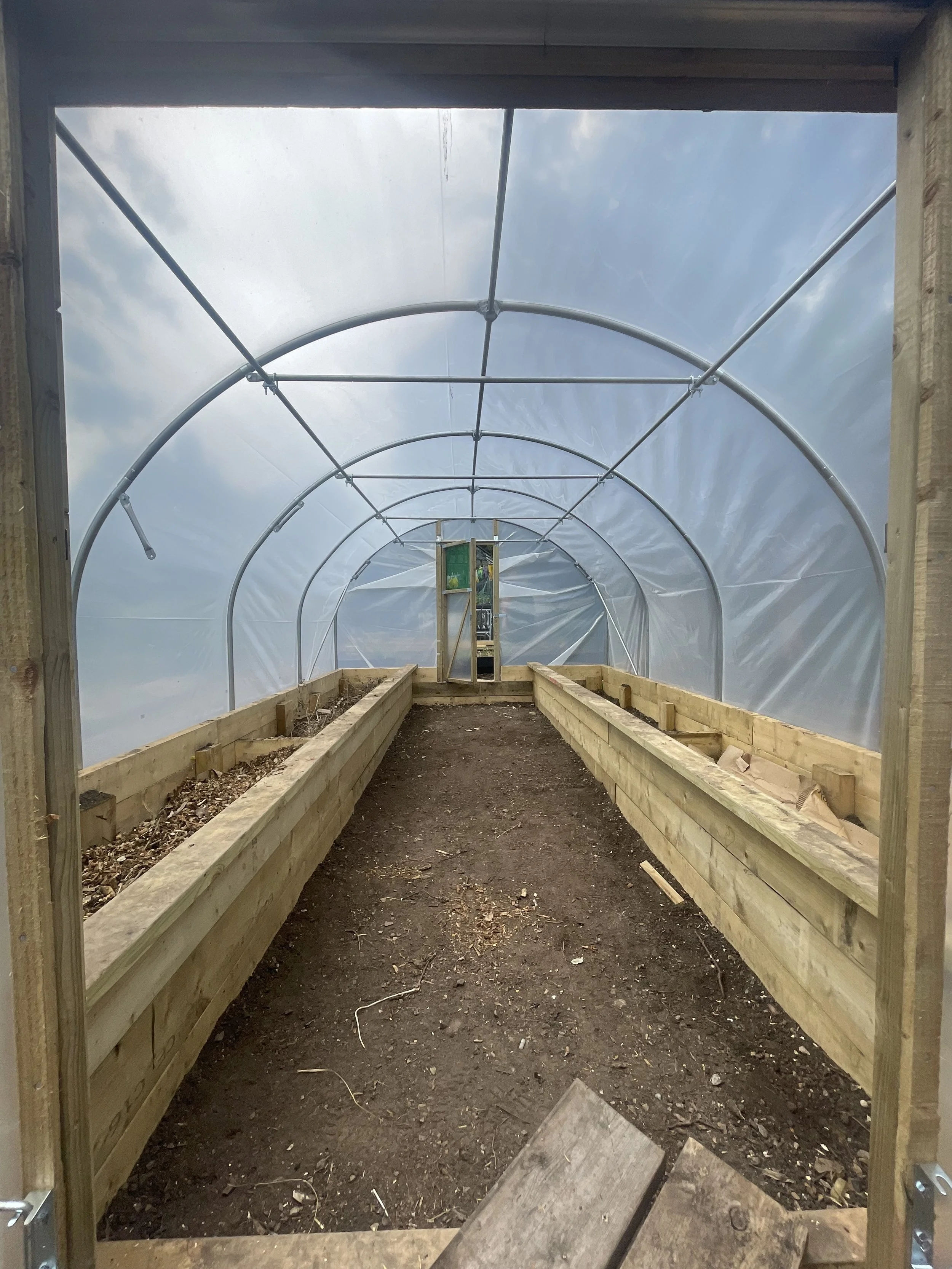 plastic on and bed ready to fill with greenwood trunks and branches, debris, cardboard, woodchip and compost  