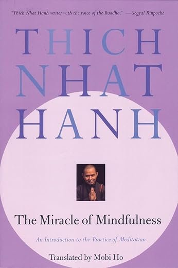 A purple background with a large lavendar circle covering the bottom 3/4th of the cover. Small image of the author at the center of the circle - a monk in dark robes smiling and joining his palms in 'namaste'