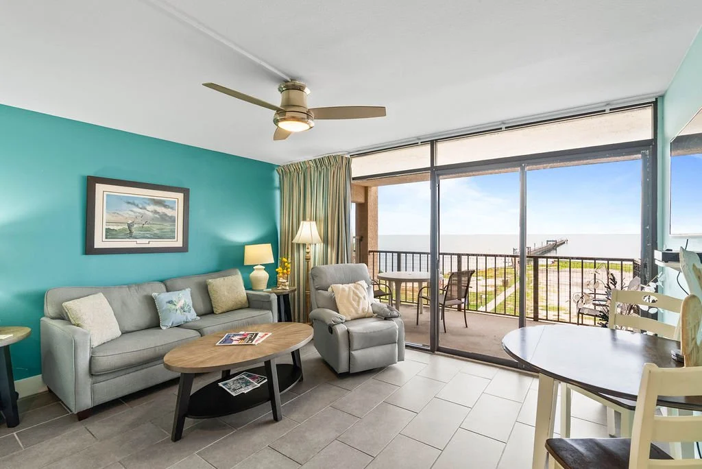 Comfortable living area with stunning bay views and direct balcony access at Beauty Blues waterfront rental, Rockport.