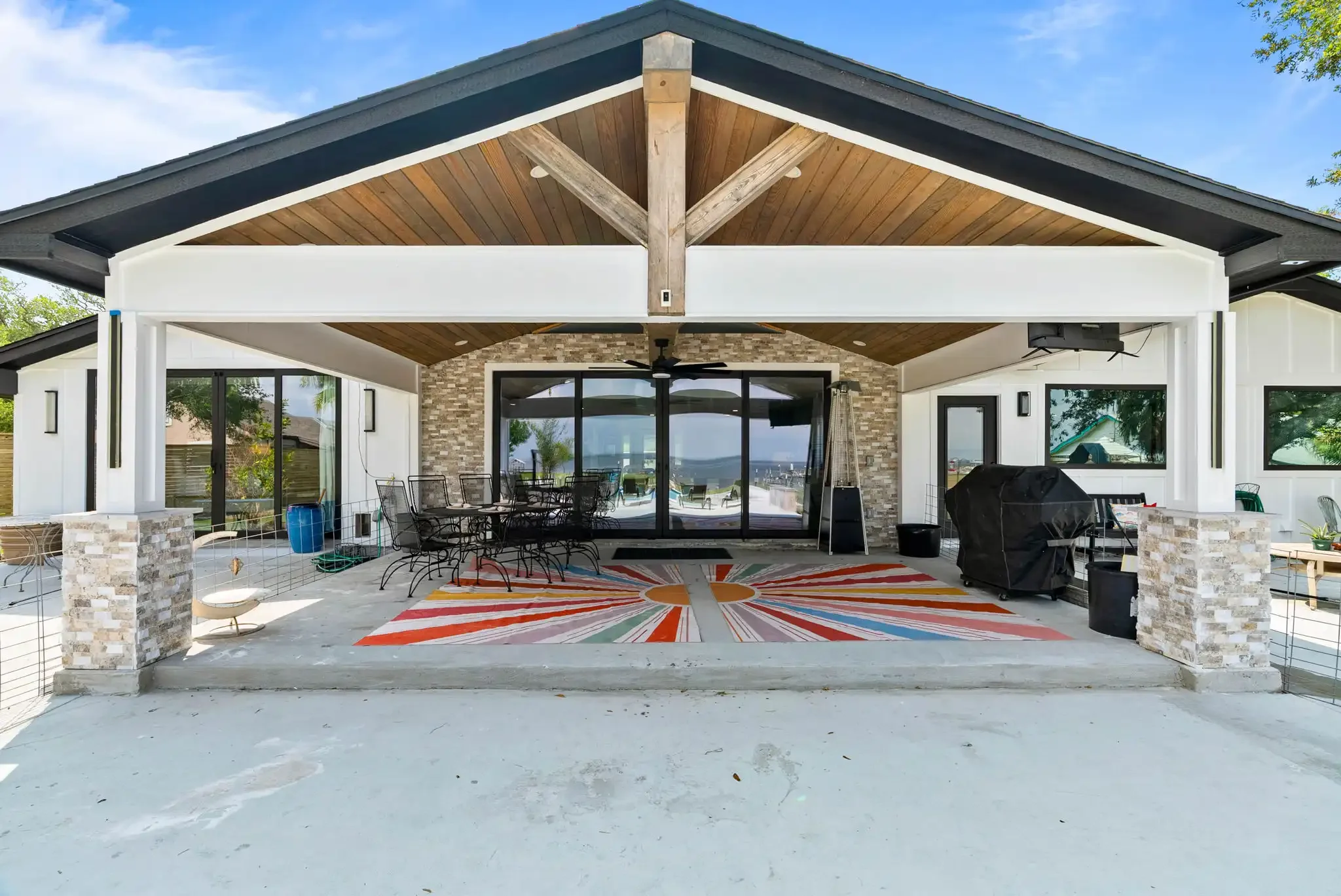 Covered outdoor living area with dining space and bay views at a luxury Rockport TX vacation rental.