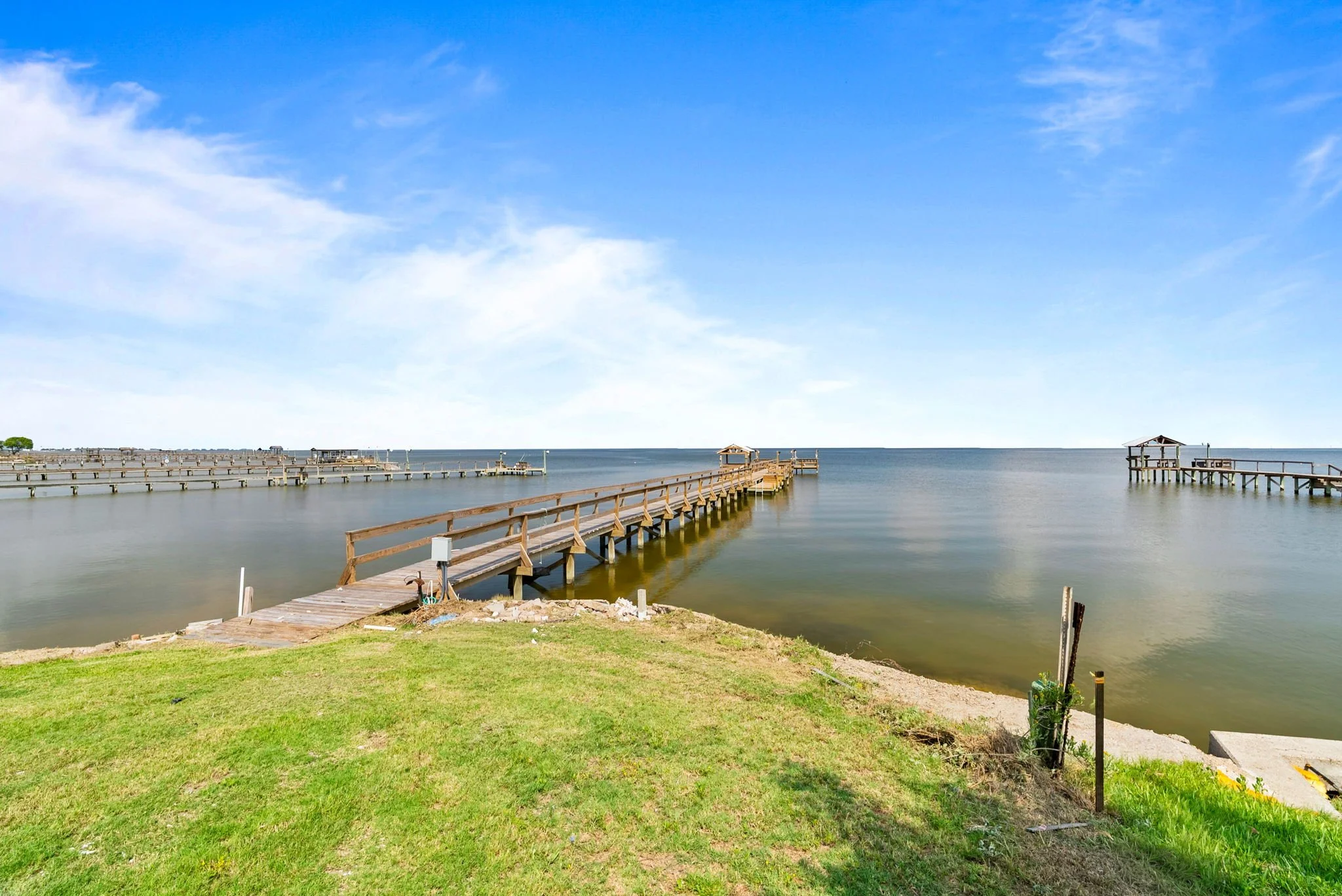 Private fishing pier extending into Aransas Bay from a luxury waterfront Rockport TX vacation rental.