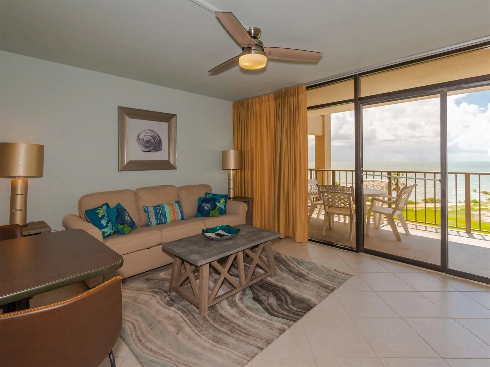 Living room with queen sleeper sofa and bay view windows – Tradewinds condo Rockport