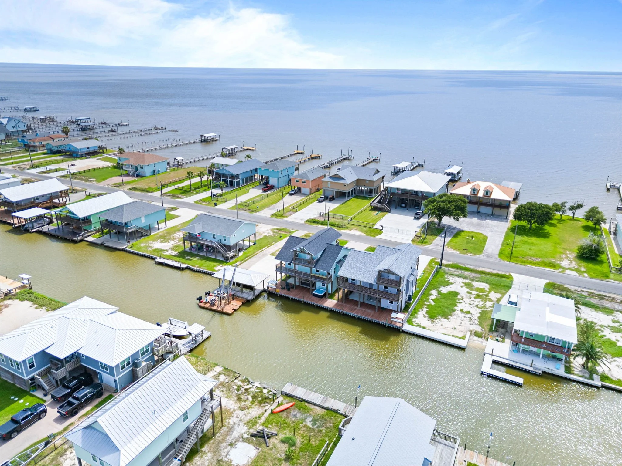 Aerial rear view of Belaire Breeze with canal-front deck, hot tub, and private waterfront access
