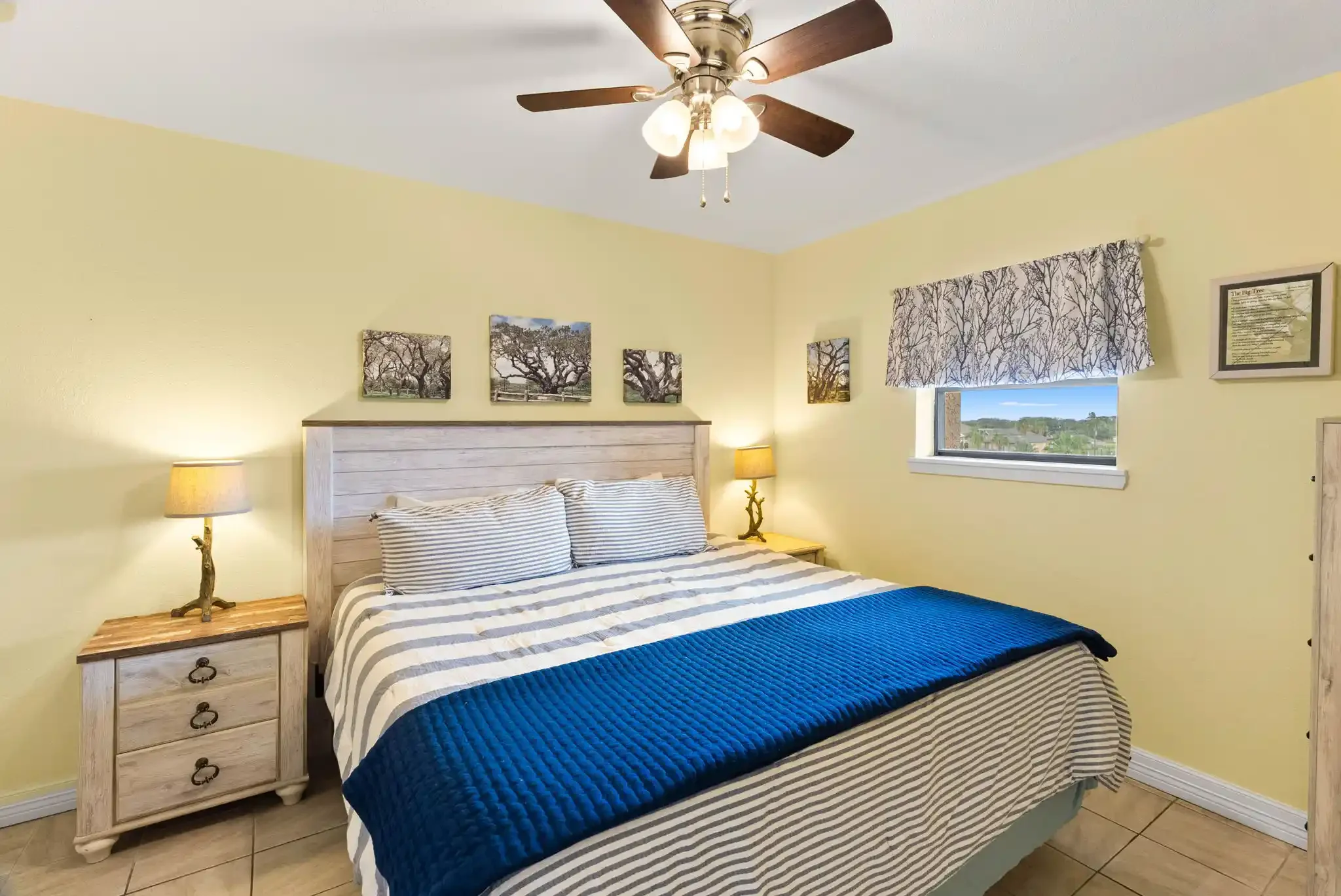 Comfortable coastal bedroom with king bed, blue accents, ceiling fan and local-inspired décor for a relaxing Rockport stay.