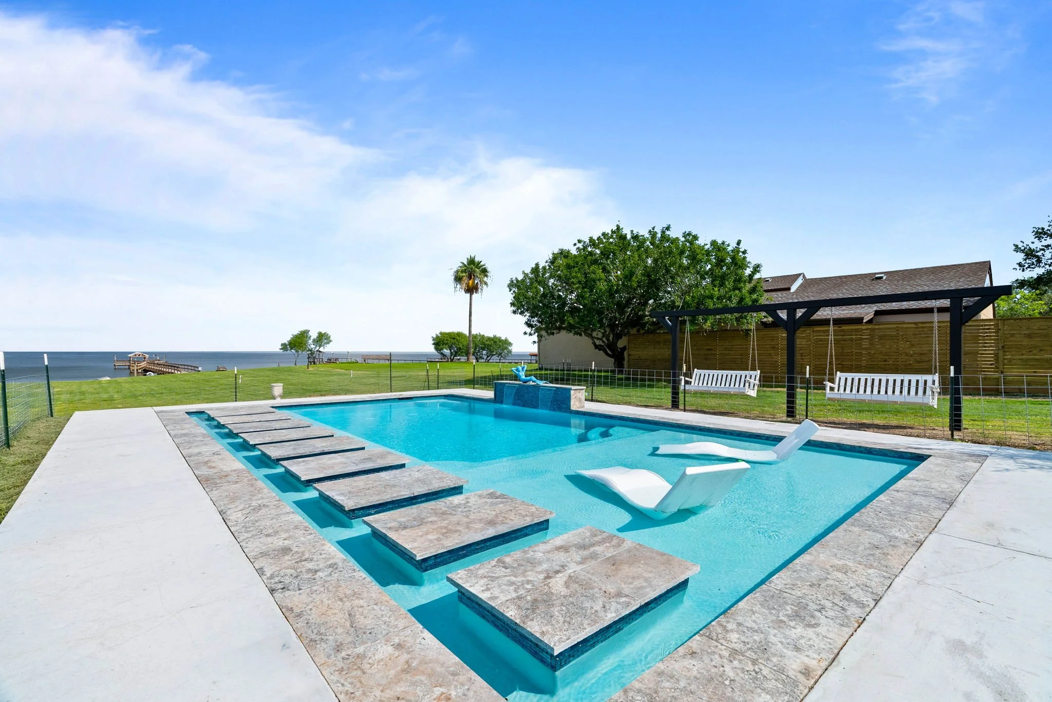 Private waterfront pool with tanning ledge and bay views at a luxury Rockport TX vacation rental.