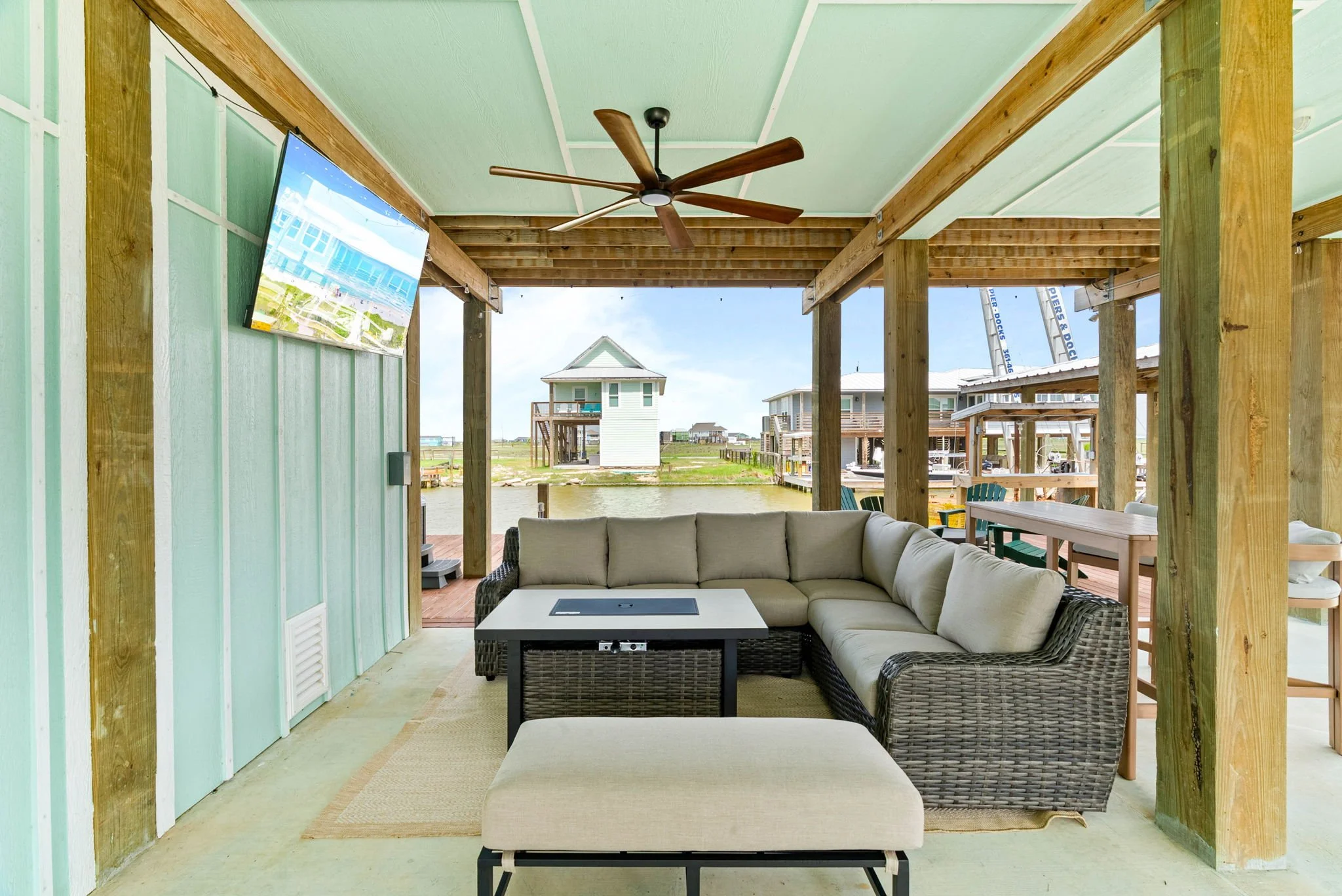 Covered canal-front balcony with outdoor seating at Belaire Breeze Holiday Beach getaway