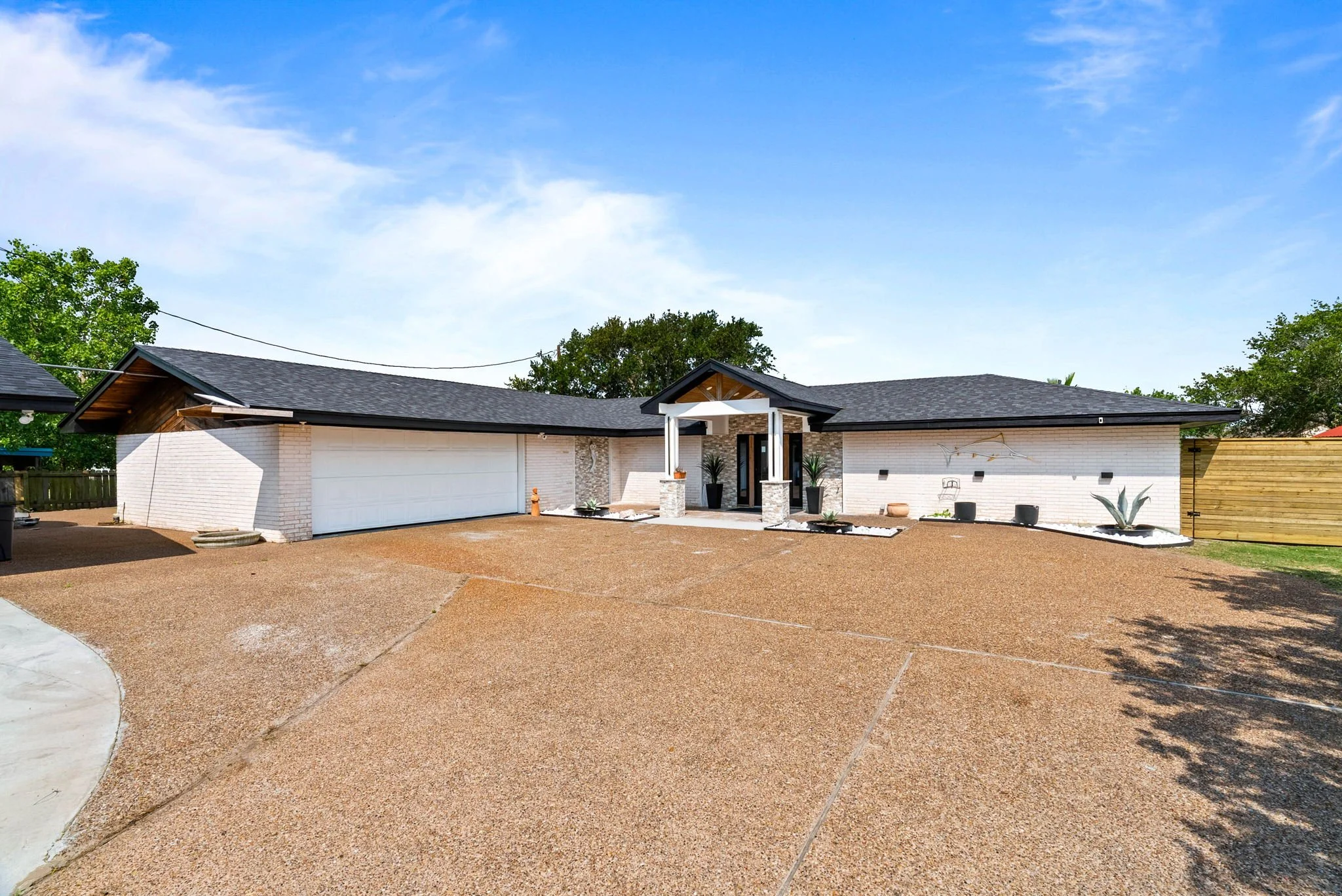 Contemporary waterfront home exterior with ample parking in a luxury Rockport TX vacation rental.