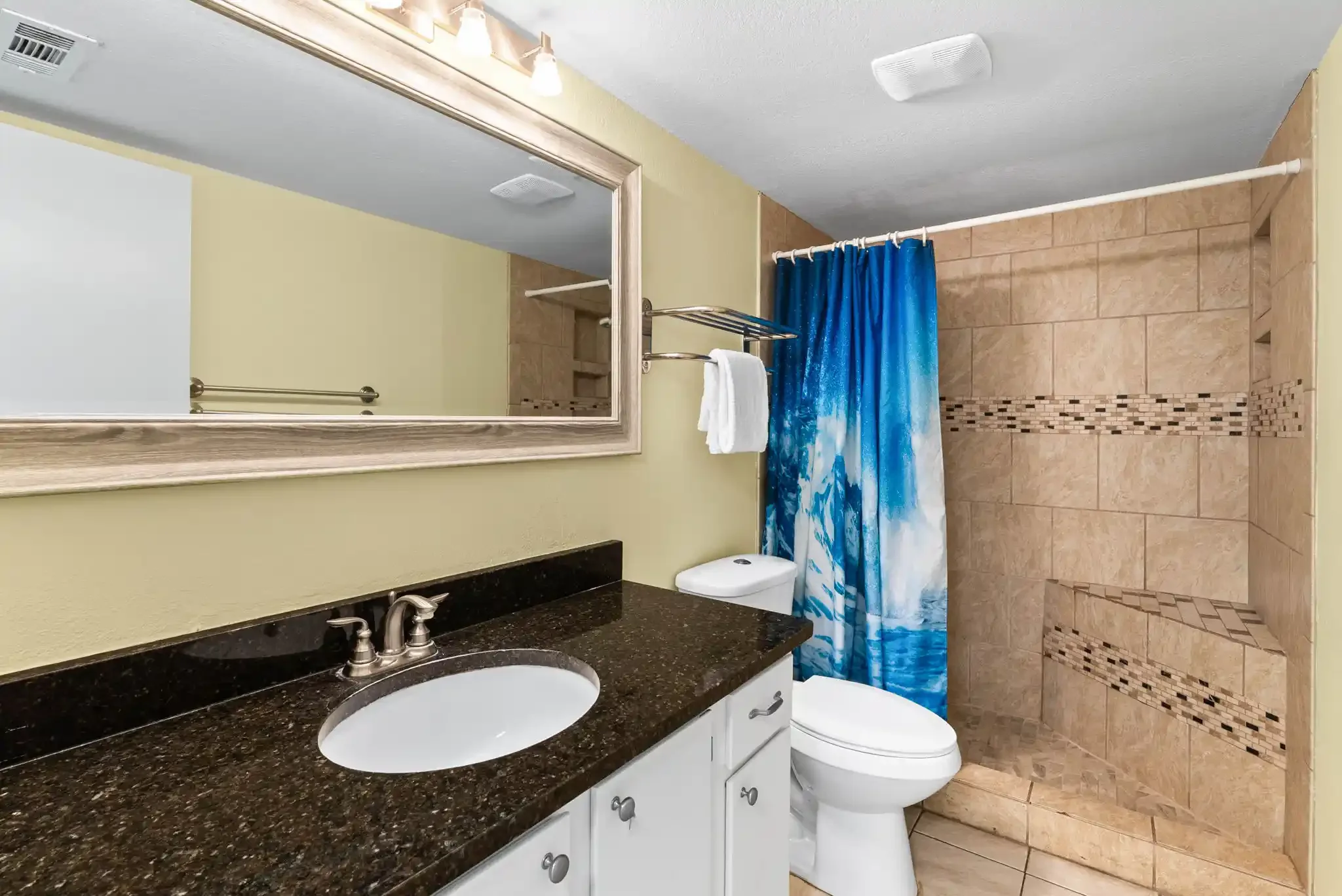 Fresh coastal bathroom featuring a granite vanity and spacious walk-in tiled shower in this Rockport TX vacation rental.