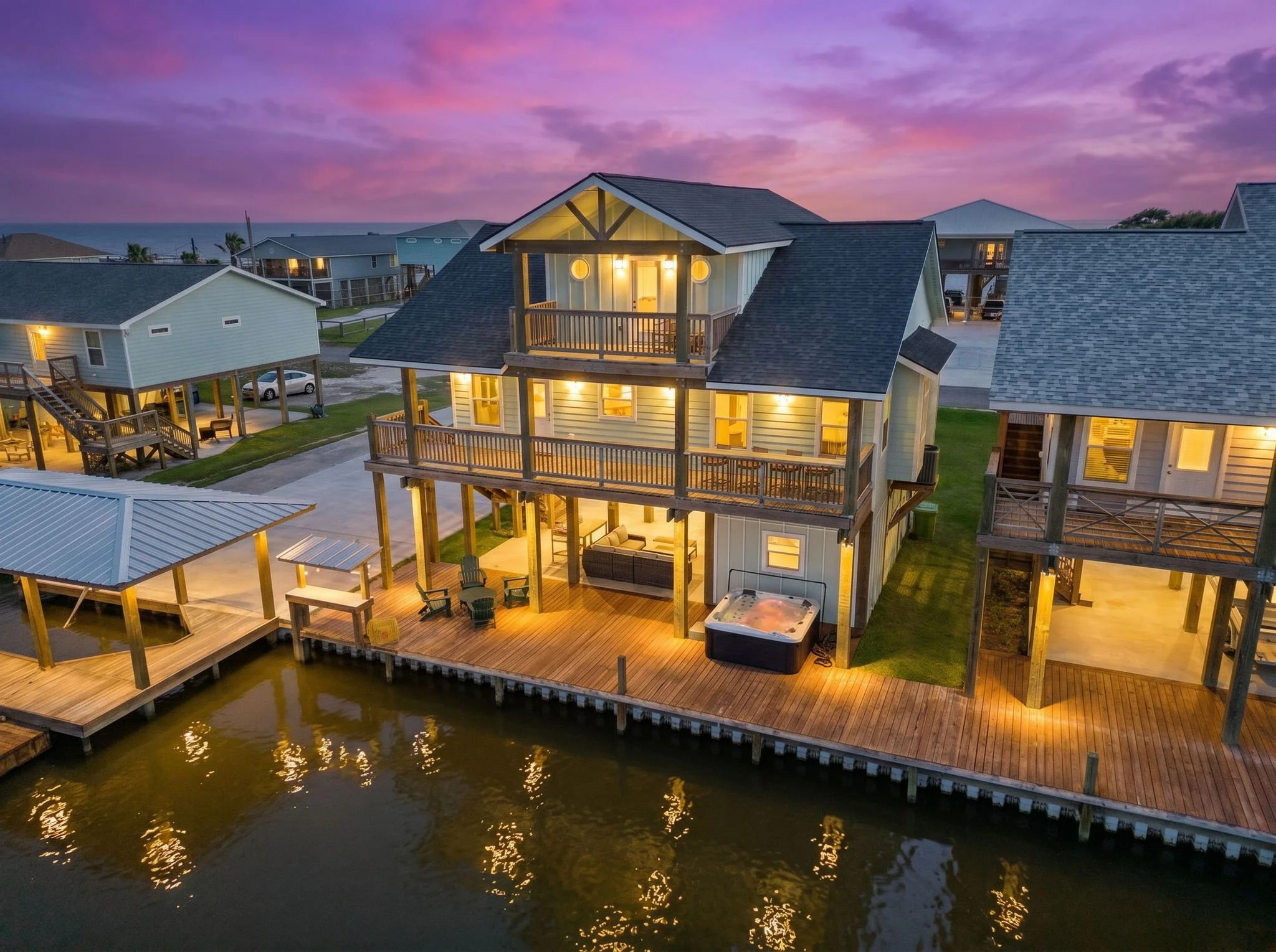 Belaire Breeze illuminated at sunset with canal-front deck and hot tub near Rockport, TX
