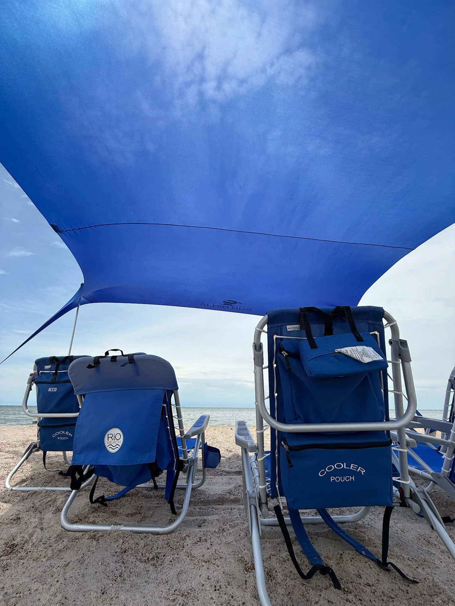 Shaded beach chair setup by the water, concierge beach day experience for guests of a luxury Rockport TX vacation rental