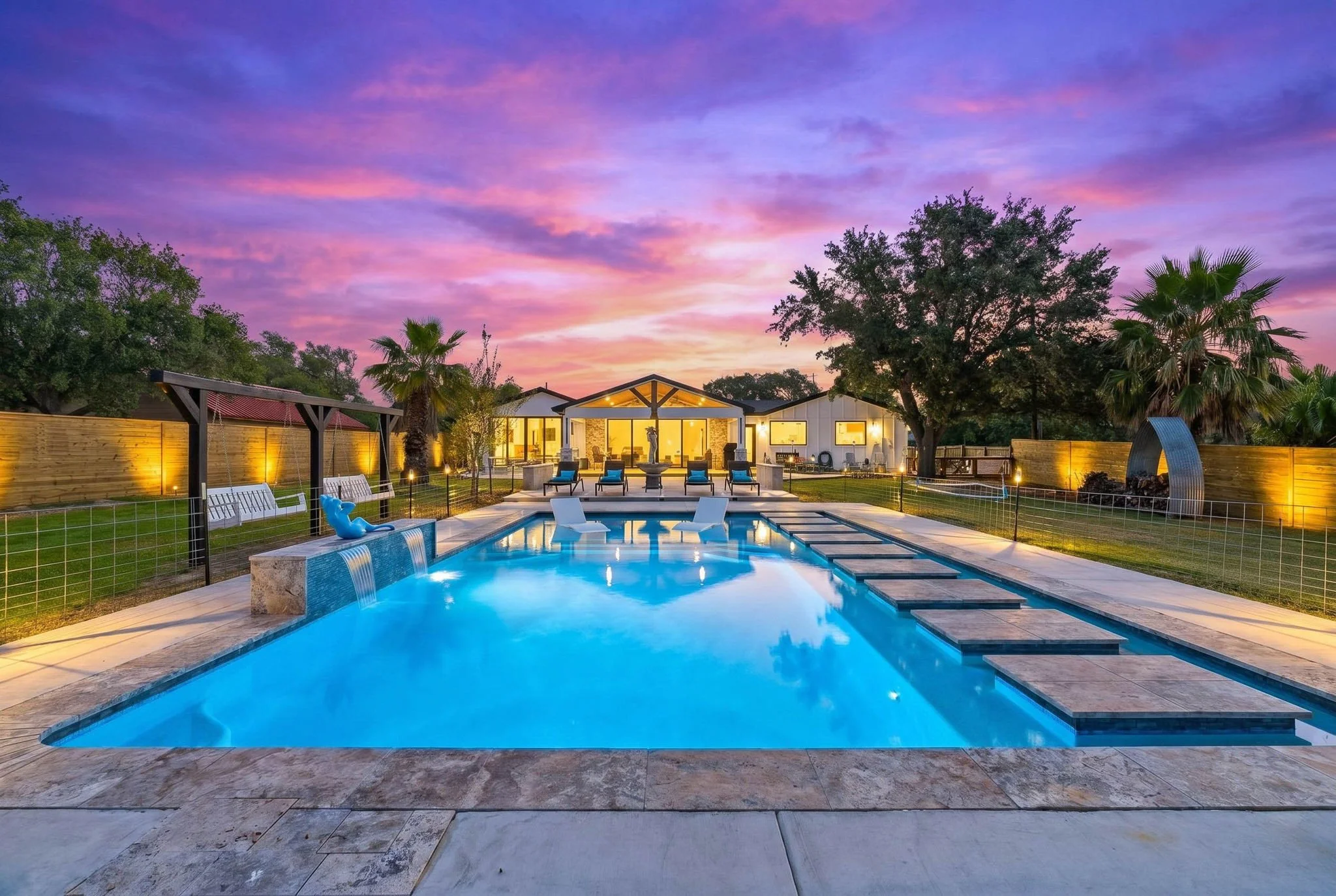Luxury waterfront pool illuminated at sunset in a premier Rockport TX vacation rental.