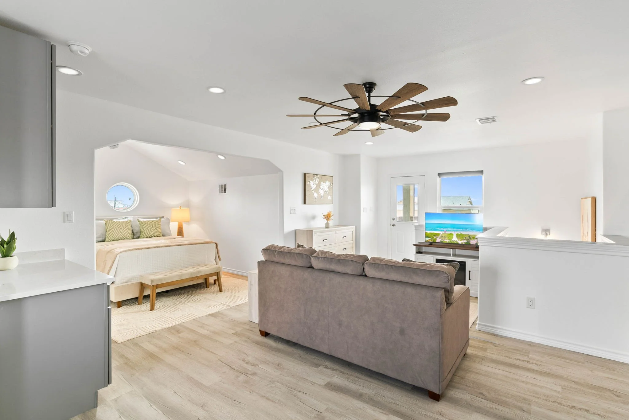 Open loft suite with queen bed, sofa, TV and bright coastal finishes