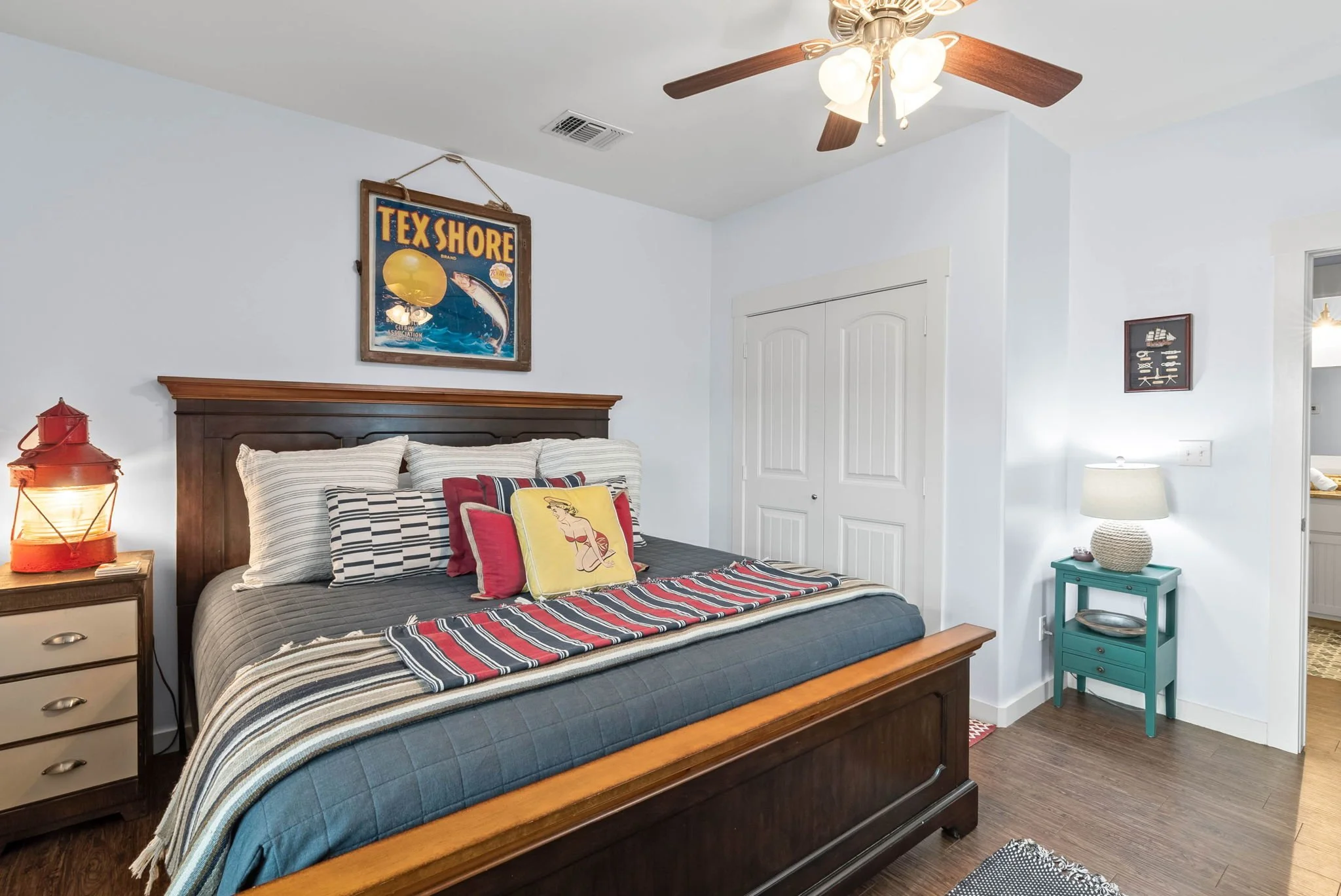 Cozy bedroom with vintage decor and ceiling fan in Rockport Texas vacation rental at Marina Del Rey