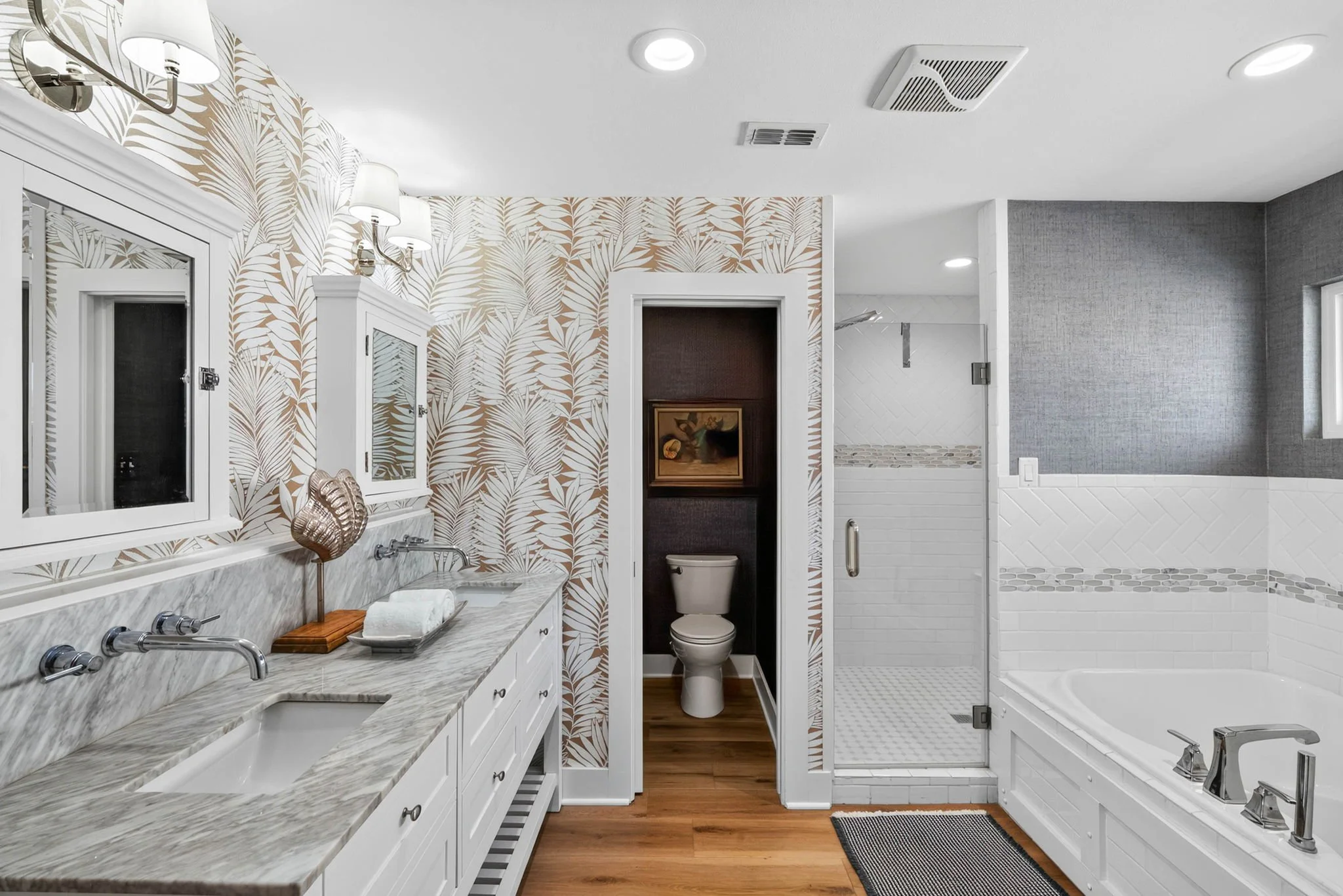 Luxury primary bathroom with dual marble vanities, soaking tub and walk-in shower at George's Landing Rockport TX 