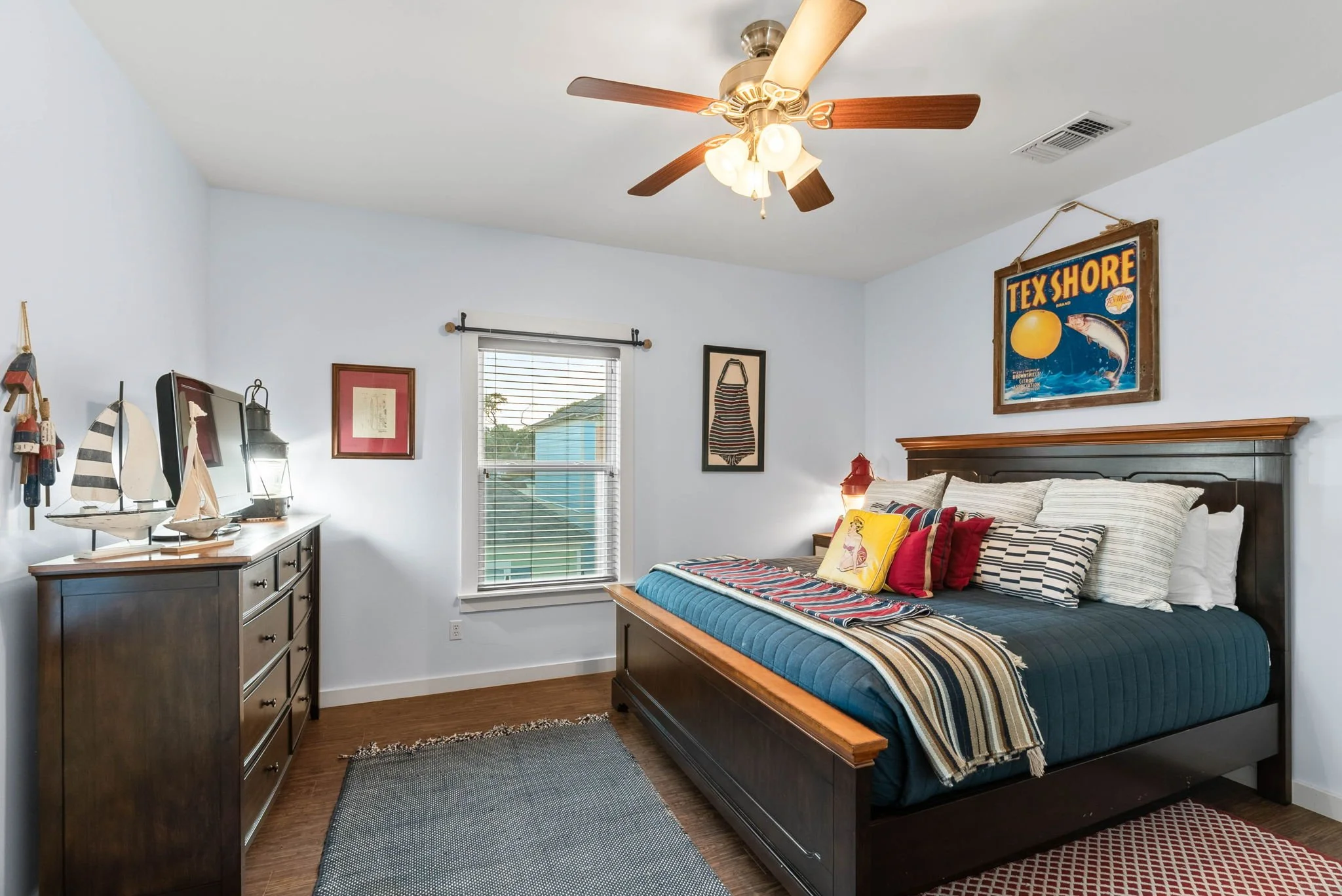 Nautical-style bedroom at Marina Del Rey Rockport TX rental with decorative sailboats and queen bed