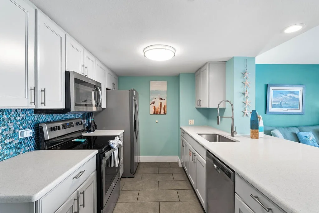 Modern kitchen with stainless steel appliances and blue tile backsplash in Beauty Blues vacation rental, Rockport TX.